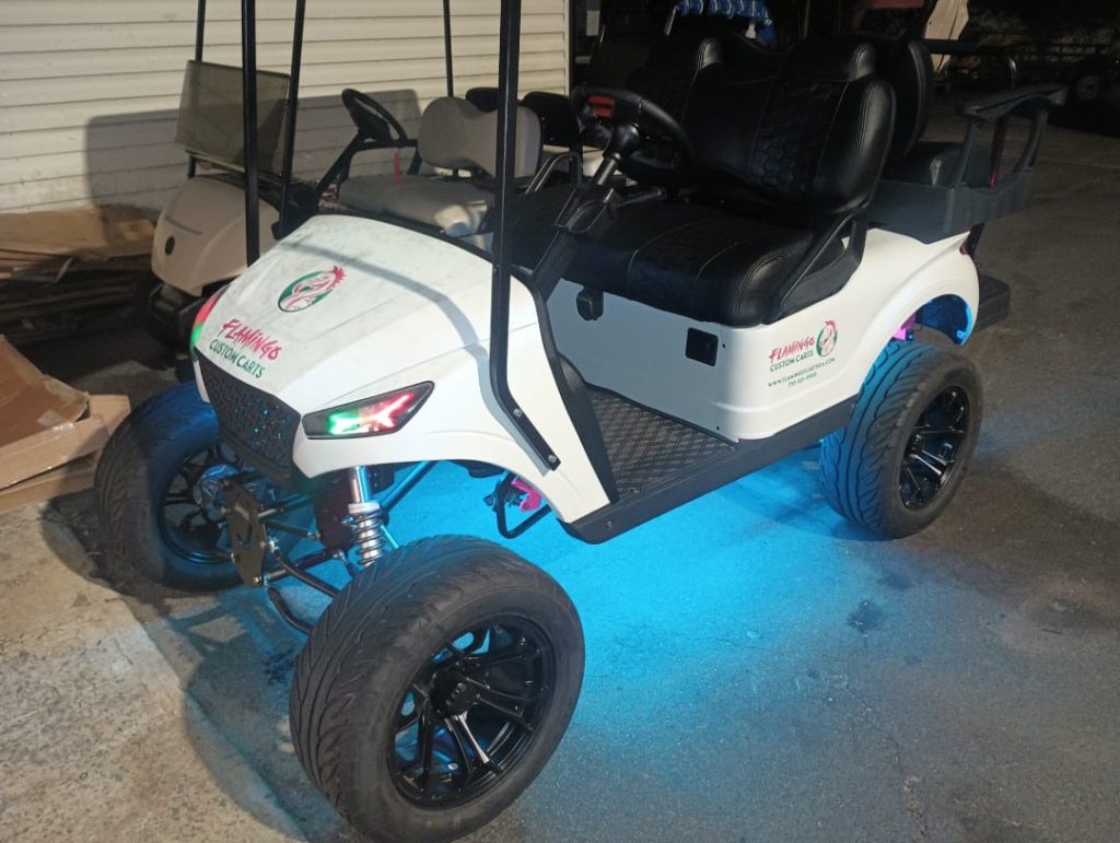 Customized white golf cart with LED lighting and Flamingos Custom Carts branding.